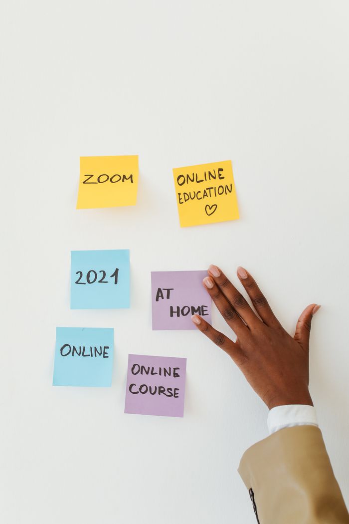 Menus Sticky notes about online education and a hand on a white wall, symbolizing remote learning.